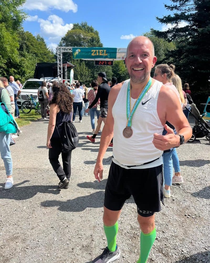 Dirk im Zielbereich eines Laufs, mit Medaille